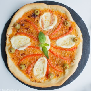 Pizza Margherita di Bufala topped with red peppers and olives