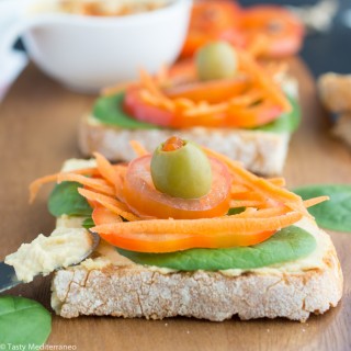 Tostas de humus con crudités y aceitunas